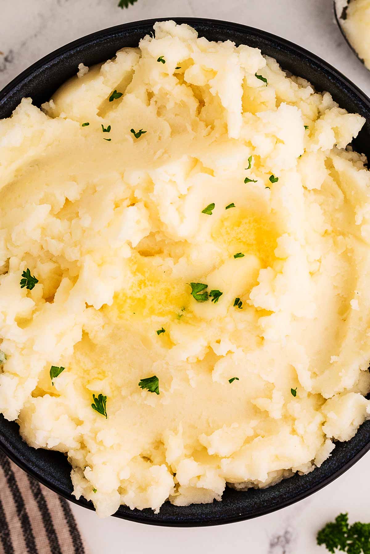 overhead close up view of mashed potatoes in black bowl
